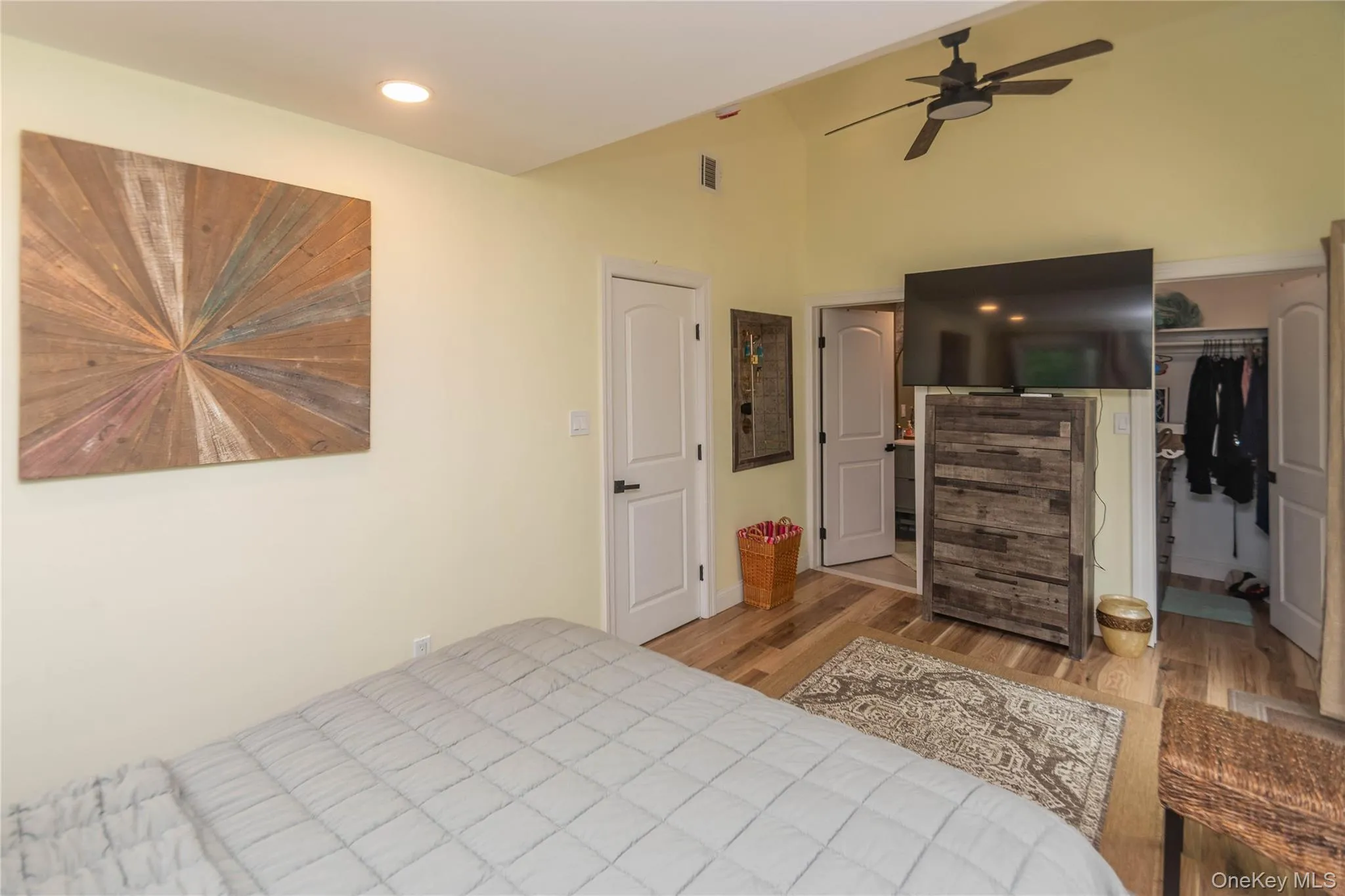 Bedroom with wood finished floors, a spacious closet, a closet, and lofted ceiling Bedroom with wood finished floors, a spacious closet, a closet, and lofted ceiling
