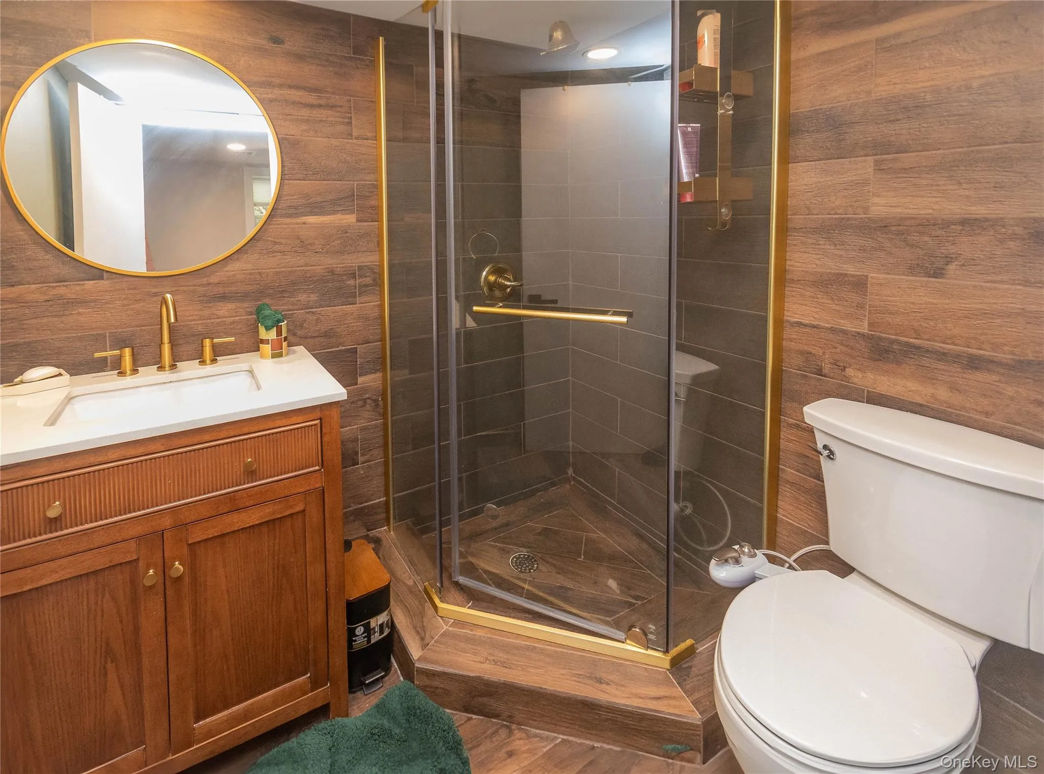 Bathroom with vanity, toilet, a stall shower, and wood walls Bathroom with vanity, toilet, a stall shower, and wood walls