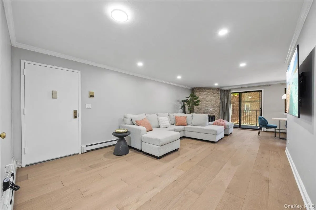 Spacious living area featuring light wood-finish flooring, recessed lighting, and crown molding Spacious living area featuring light wood-finish flooring, recessed lighting, and crown molding