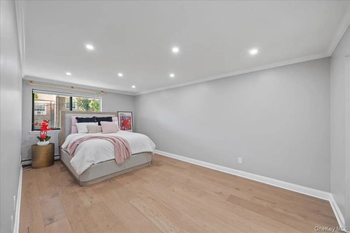 Spacious room with light wood-finish flooring, recessed lighting, and crown molding Spacious room with light wood-finish flooring, recessed lighting, and crown molding