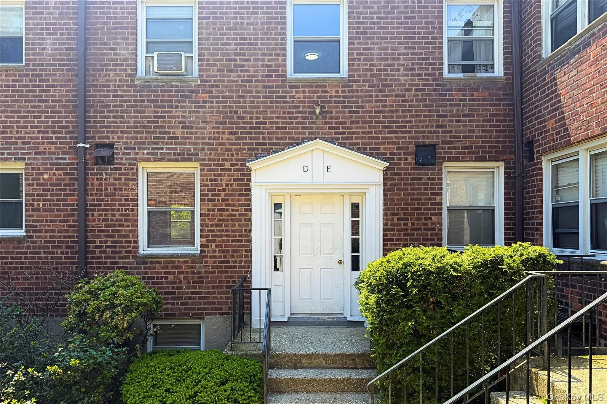 Brick facade building with a prominent white portico entry featuring side lites and a transom window Brick facade building with a prominent white portico entry featuring side lites and a transom window