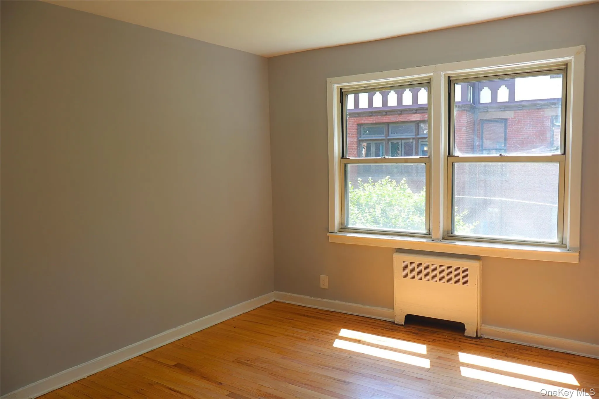 Bedroom with Hardwood flooring, neutral painted walls, and white trim Bedroom with Hardwood flooring, neutral painted walls, and white trim