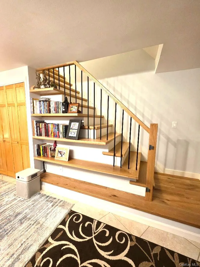 Beautiful wood stairs with shelving leading to full basement Beautiful wood stairs with shelving leading to full basement
