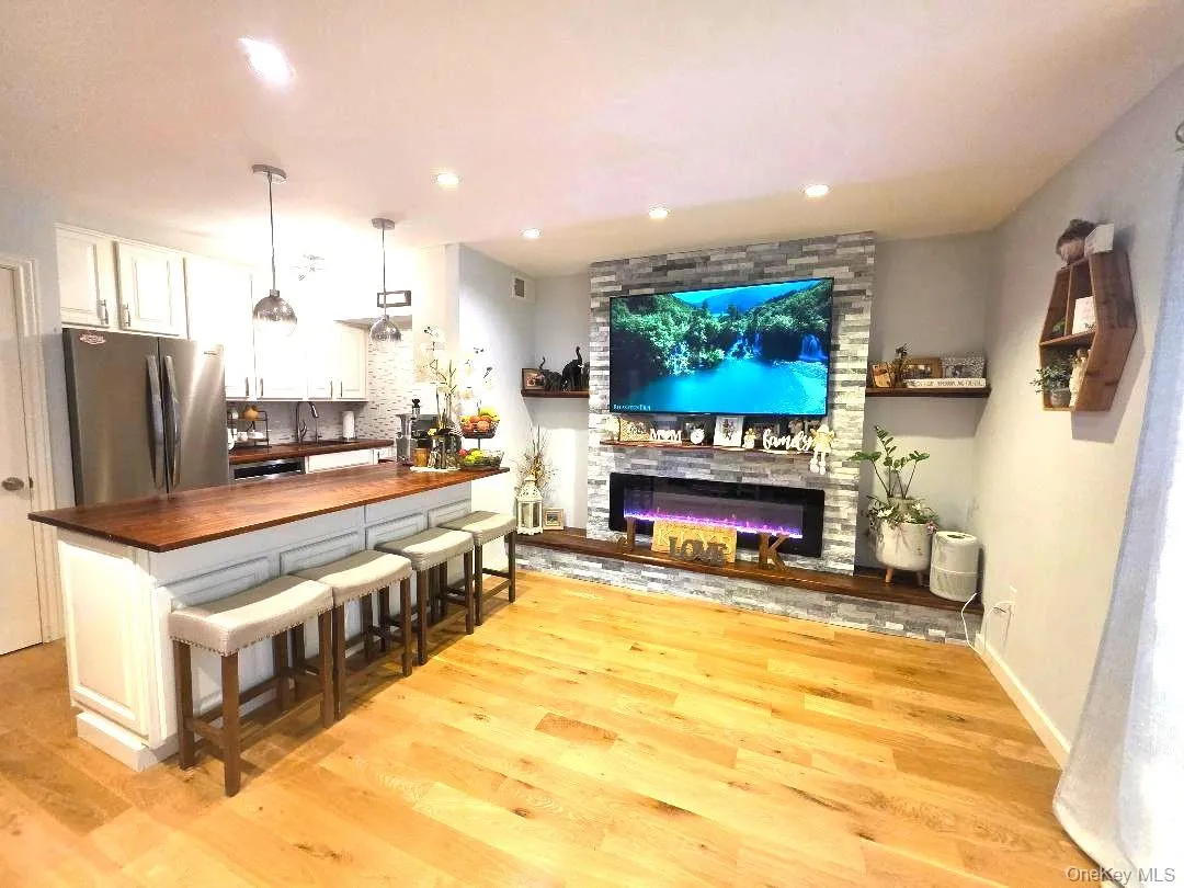 Living room with fireplace and eat-in-kitchen with stainless appliances and pantry Living room with fireplace and eat-in-kitchen with stainless appliances and pantry