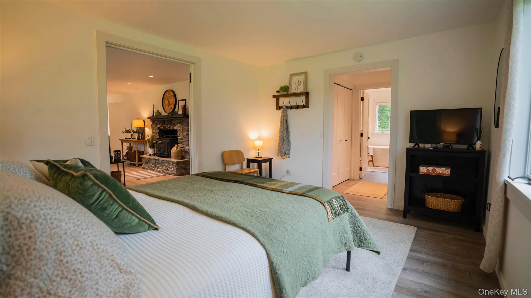 Bedroom with wood finished floors, a fireplace, and ensuite bathroom Bedroom with wood finished floors, a fireplace, and ensuite bathroom