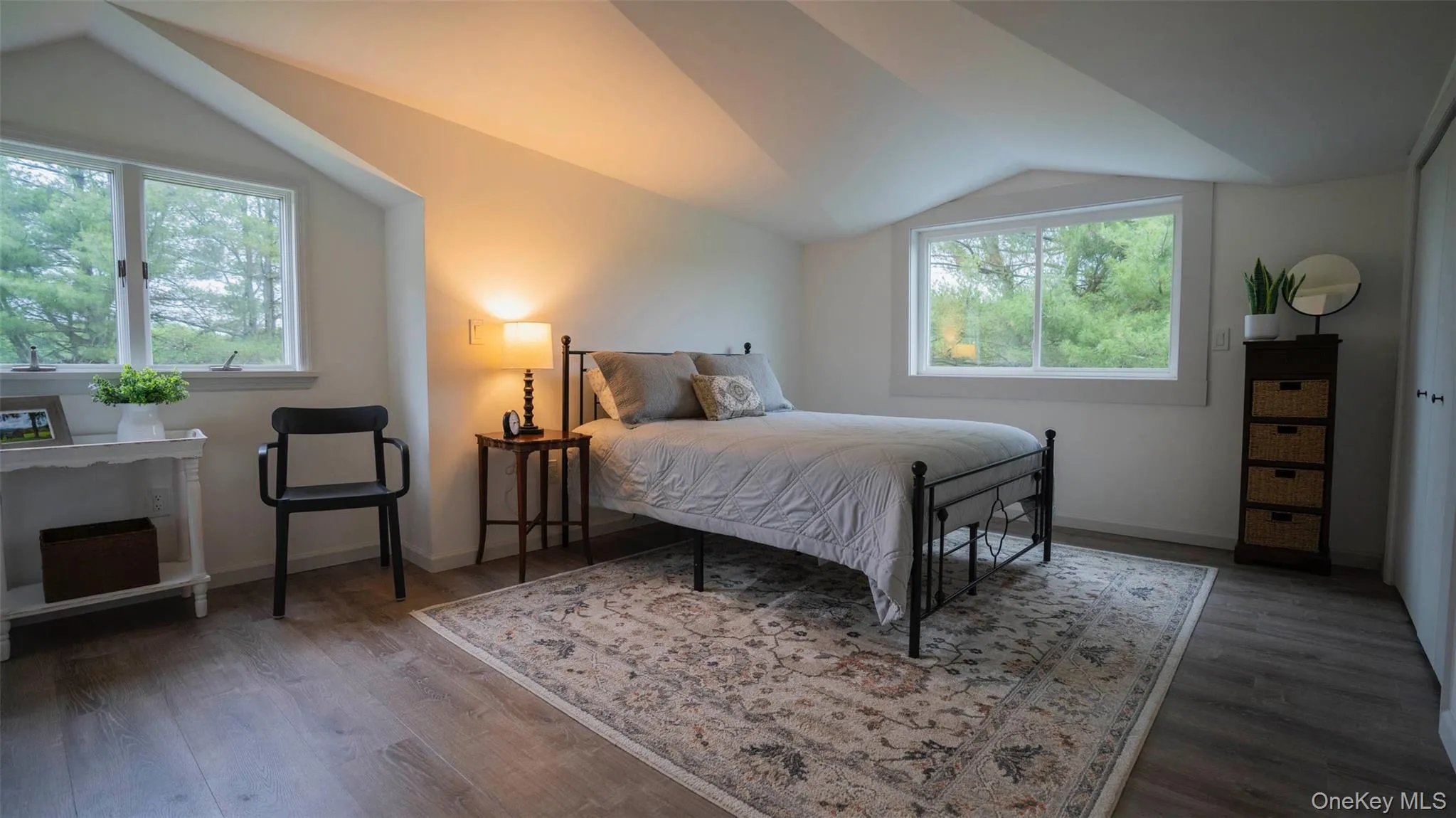 Bedroom featuring vaulted ceiling, multiple windows, and wood finished floors Bedroom featuring vaulted ceiling, multiple windows, and wood finished floors