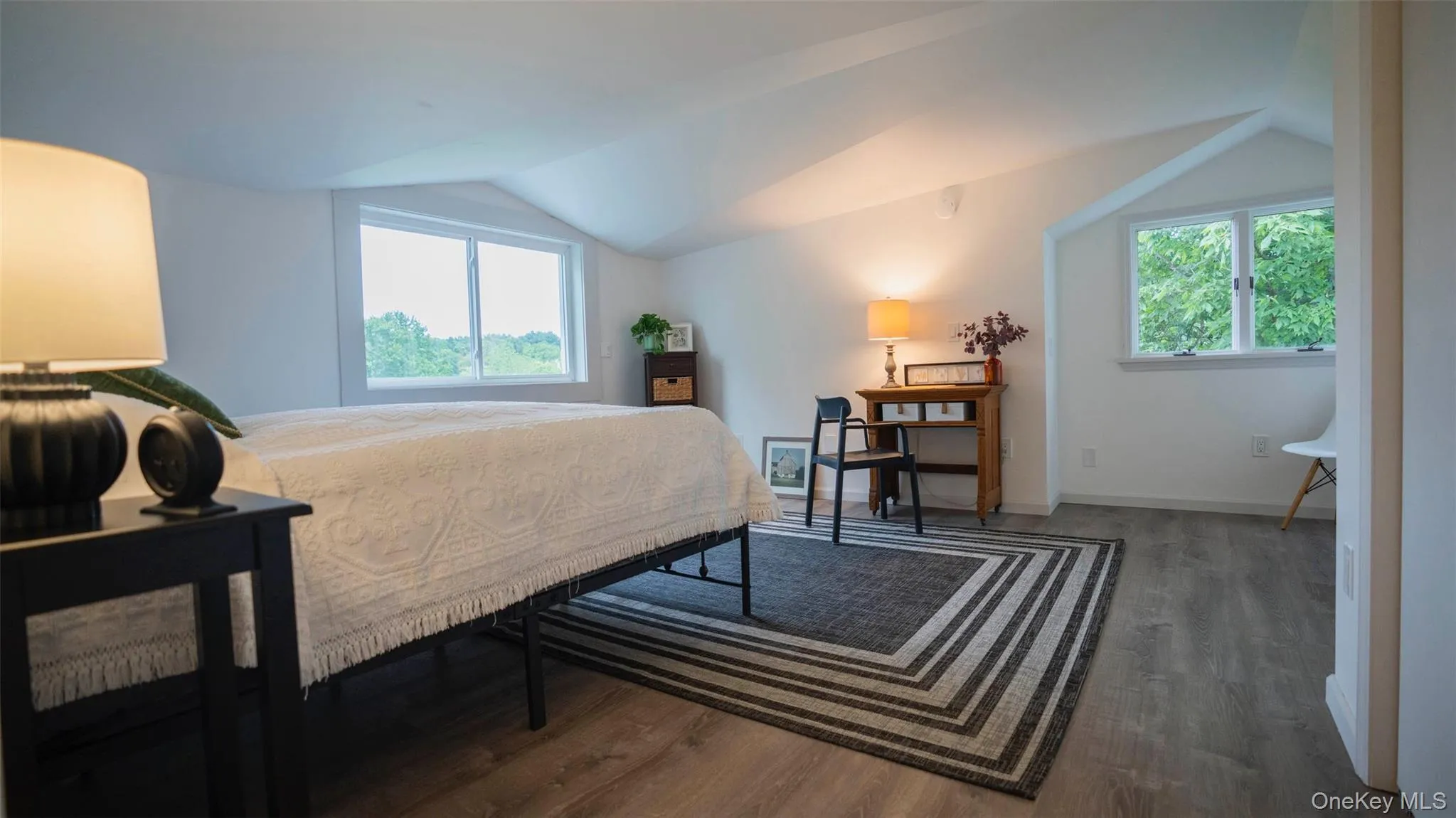 Bedroom featuring lofted ceiling and wood finished floors Bedroom featuring lofted ceiling and wood finished floors