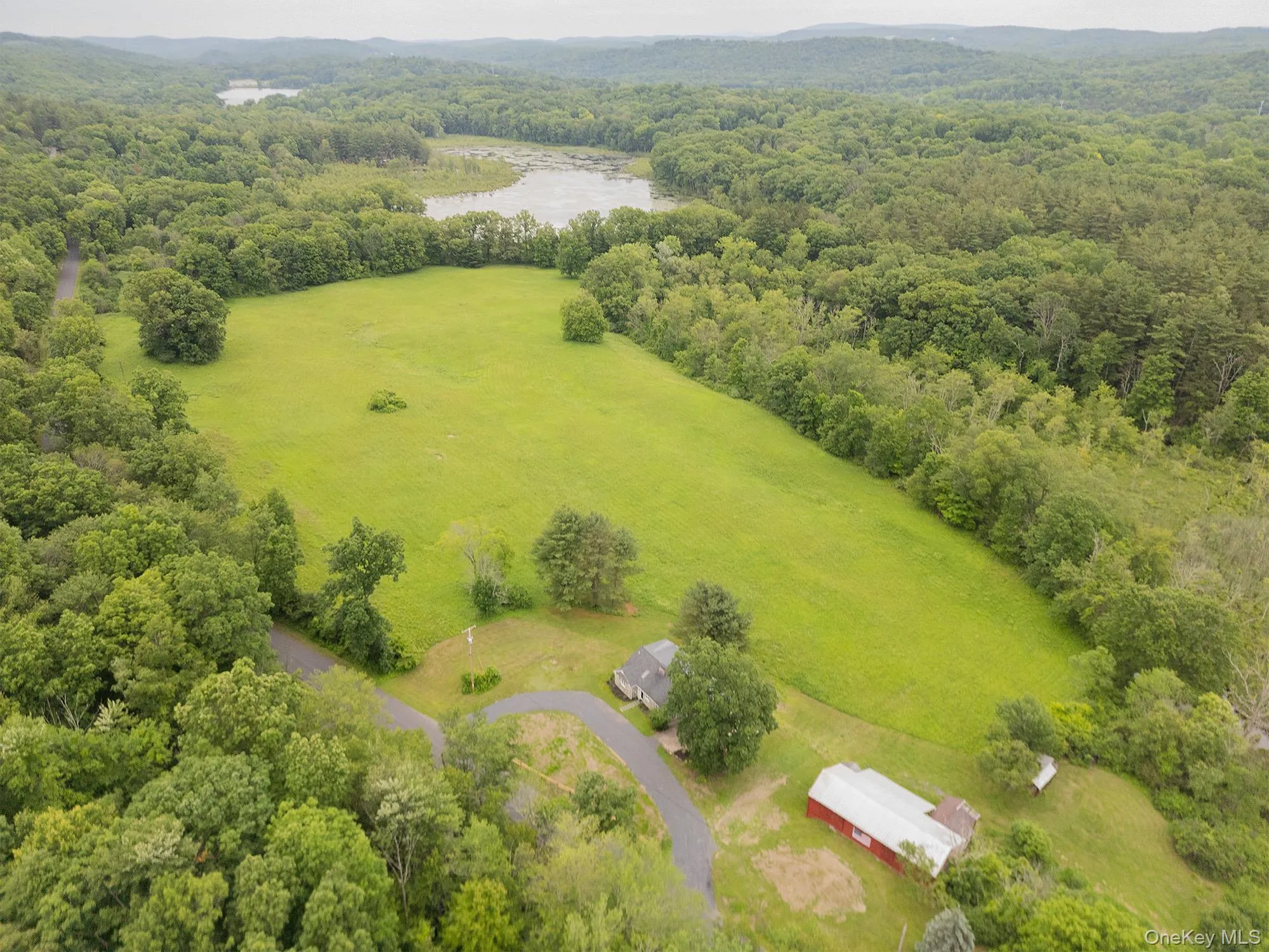 Aerial view of a nearby body of water and a heavily wooded area Aerial view of a nearby body of water and a heavily wooded area