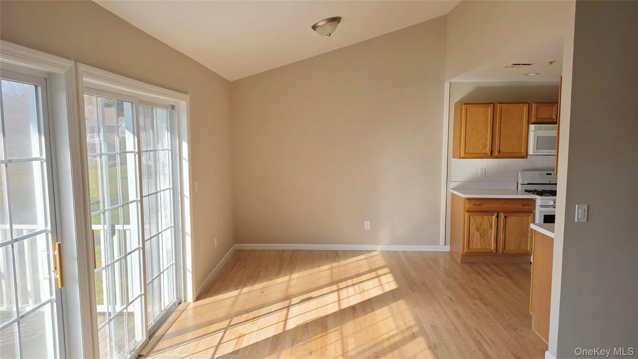 Dining Room open to living room and kitchen with French door style slider to balcony Dining Room open to living room and kitchen with French door style slider to balcony