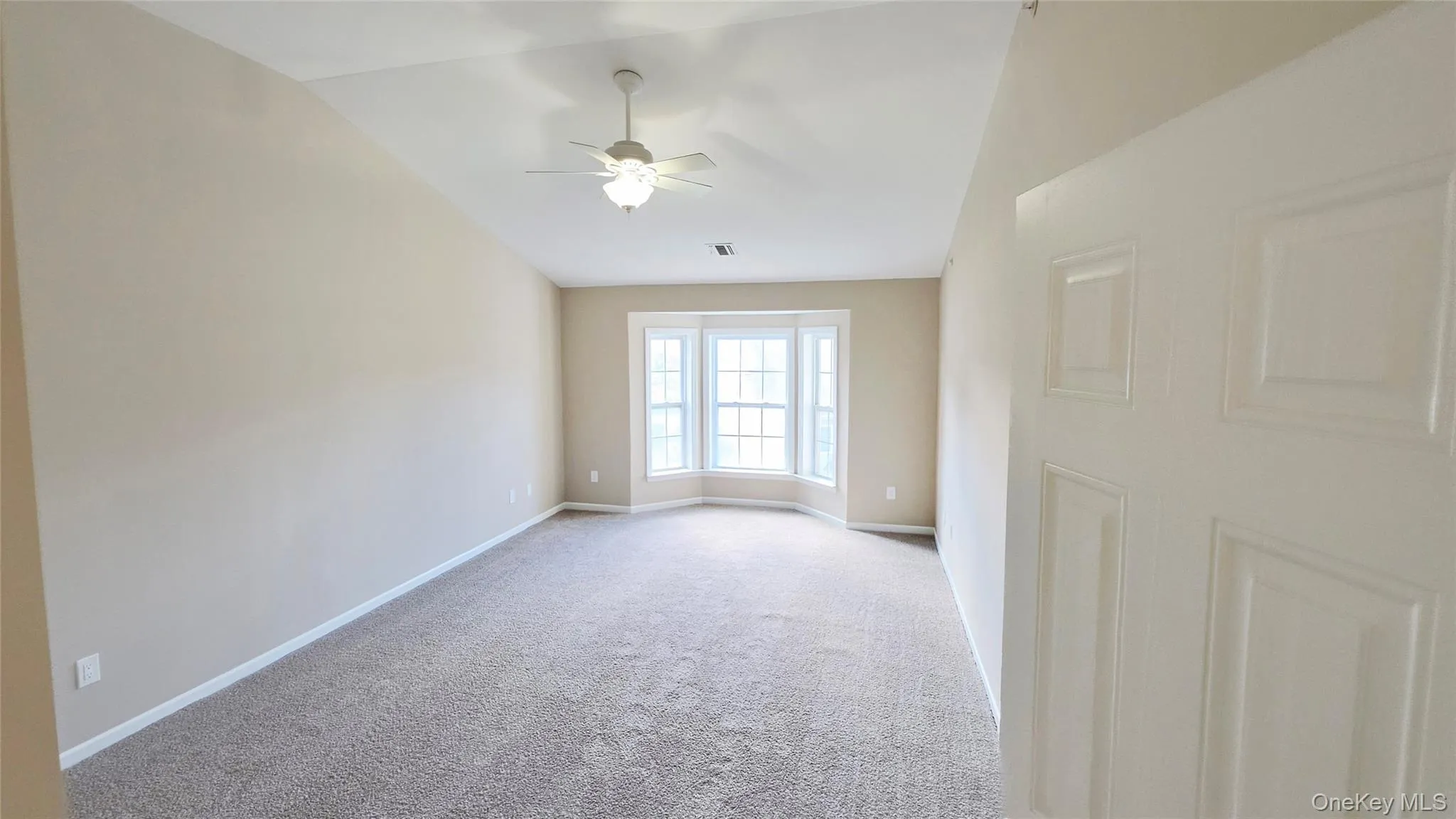 Primary bedroom with vaulted ceiling and bay window. Primary bedroom with vaulted ceiling and bay window.