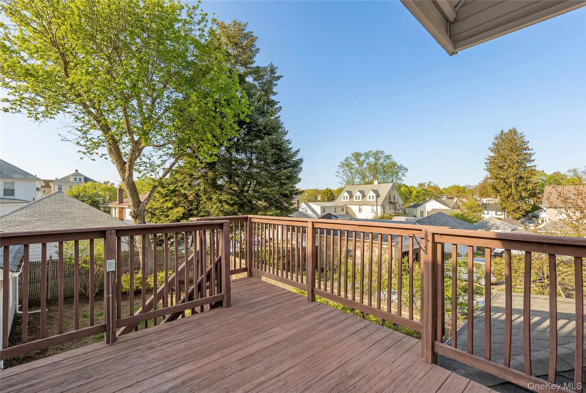 Elevated wood-finish deck with full railings Elevated wood-finish deck with full railings