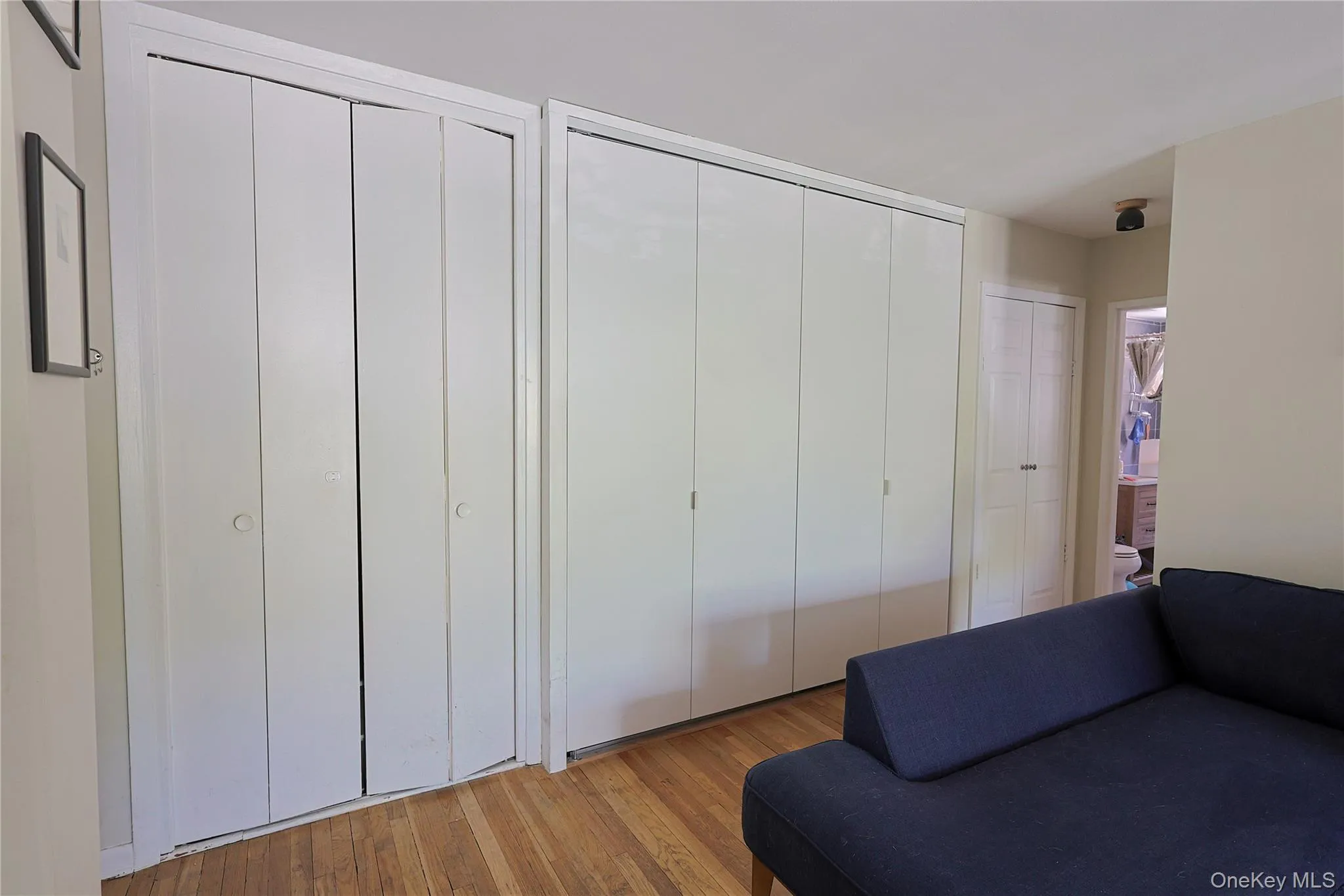 Hardwood flooring complemented by a wall of white bi-fold closet doors Hardwood flooring complemented by a wall of white bi-fold closet doors