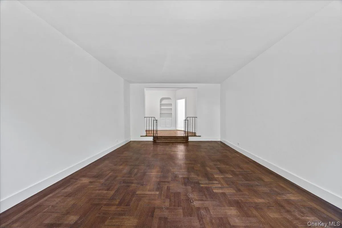 Spacious interior featuring hardwood floor, white walls Spacious interior featuring hardwood floor, white walls