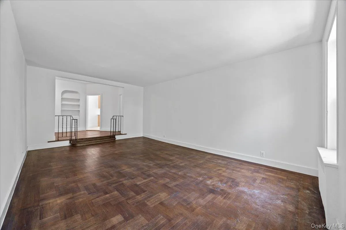 Spacious interior featuring hardwood floor, white walls Spacious interior featuring hardwood floor, white walls