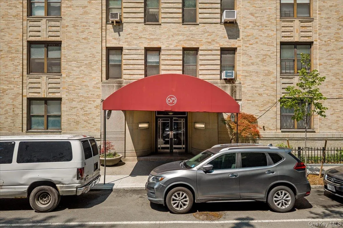 Brick facade building entrance with a red awning Brick facade building entrance with a red awning