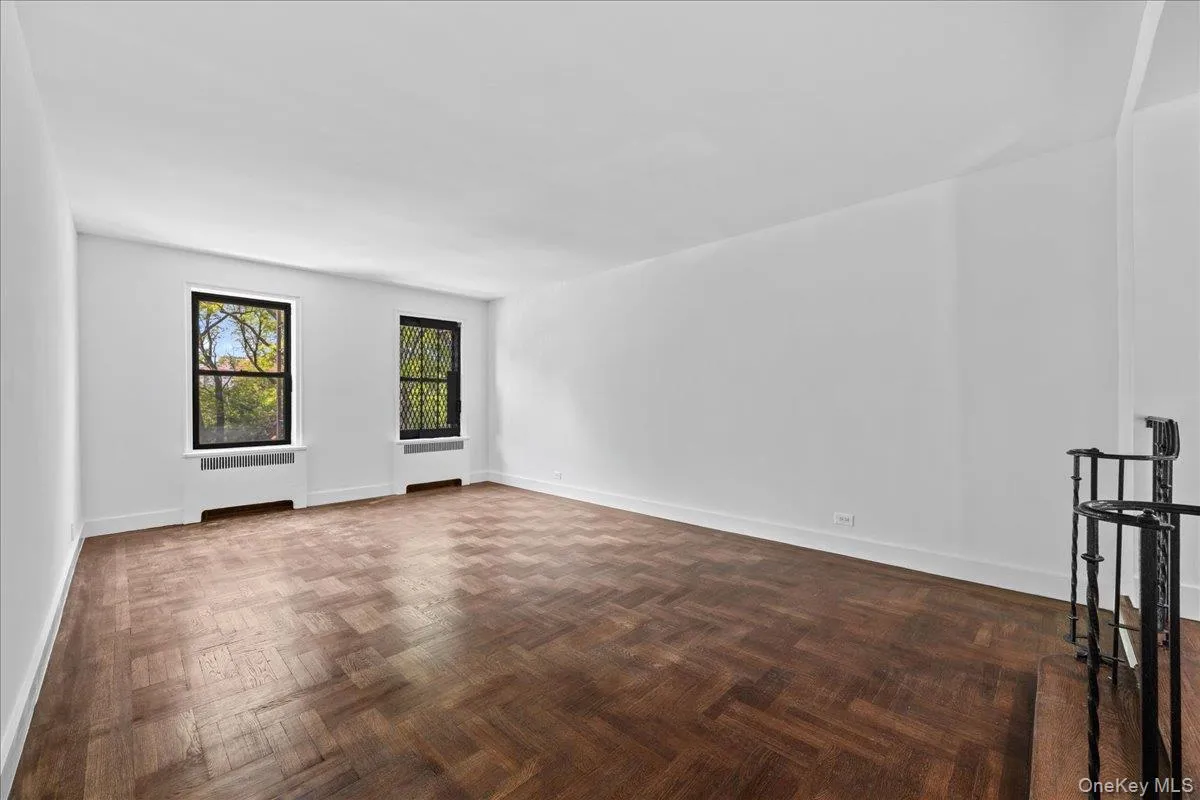 Spacious interior featuring hardwood floor, white walls Spacious interior featuring hardwood floor, white walls