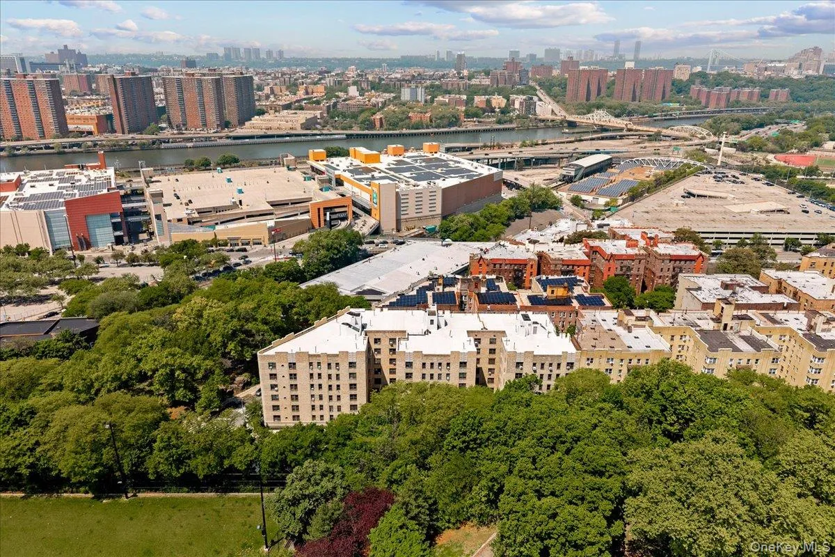 Elevated urban property featuring a multi-story building with numerous windows, surrounded by mature trees Elevated urban property featuring a multi-story building with numerous windows, surrounded by mature trees
