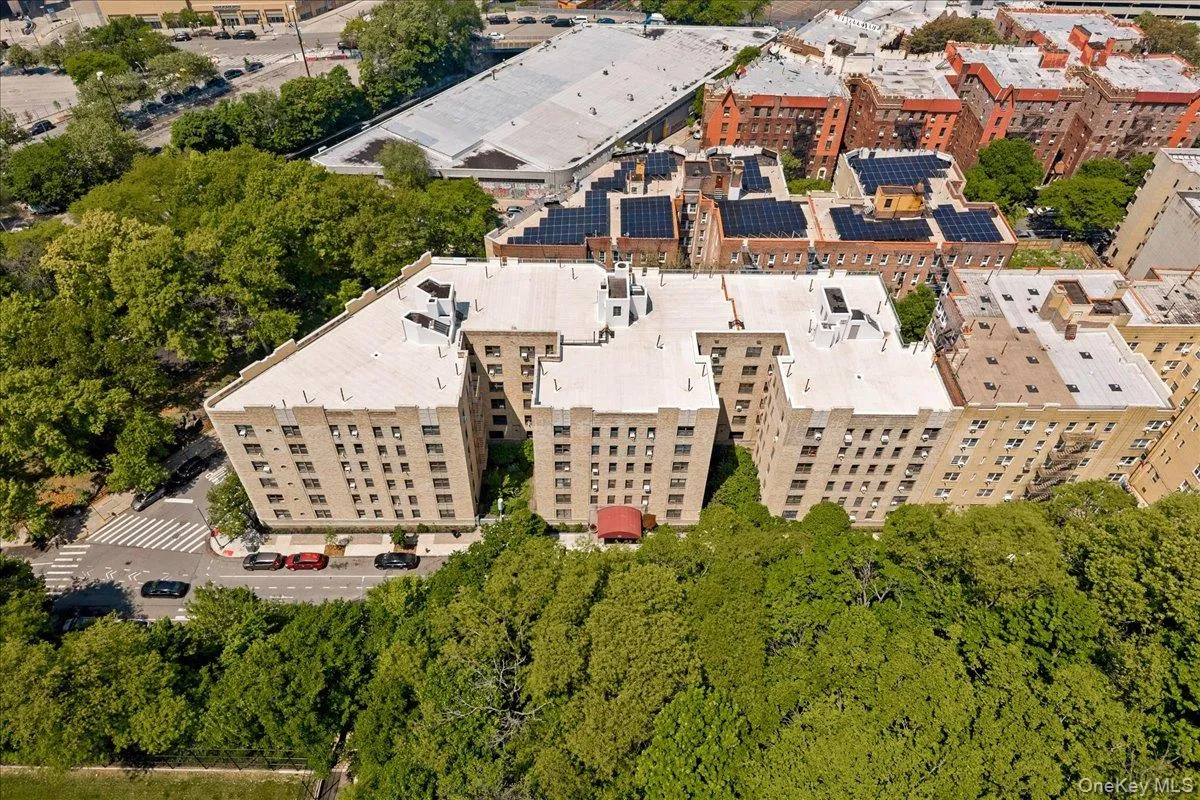 Multi-story building featuring a light-colored exterior facade, flat roofline, multiple windows, and a red awning at the entrance Multi-story building featuring a light-colored exterior facade, flat roofline, multiple windows, and a red awning at the entrance