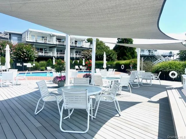 Deck with outdoor dining space and a community pool Deck with outdoor dining space and a community pool