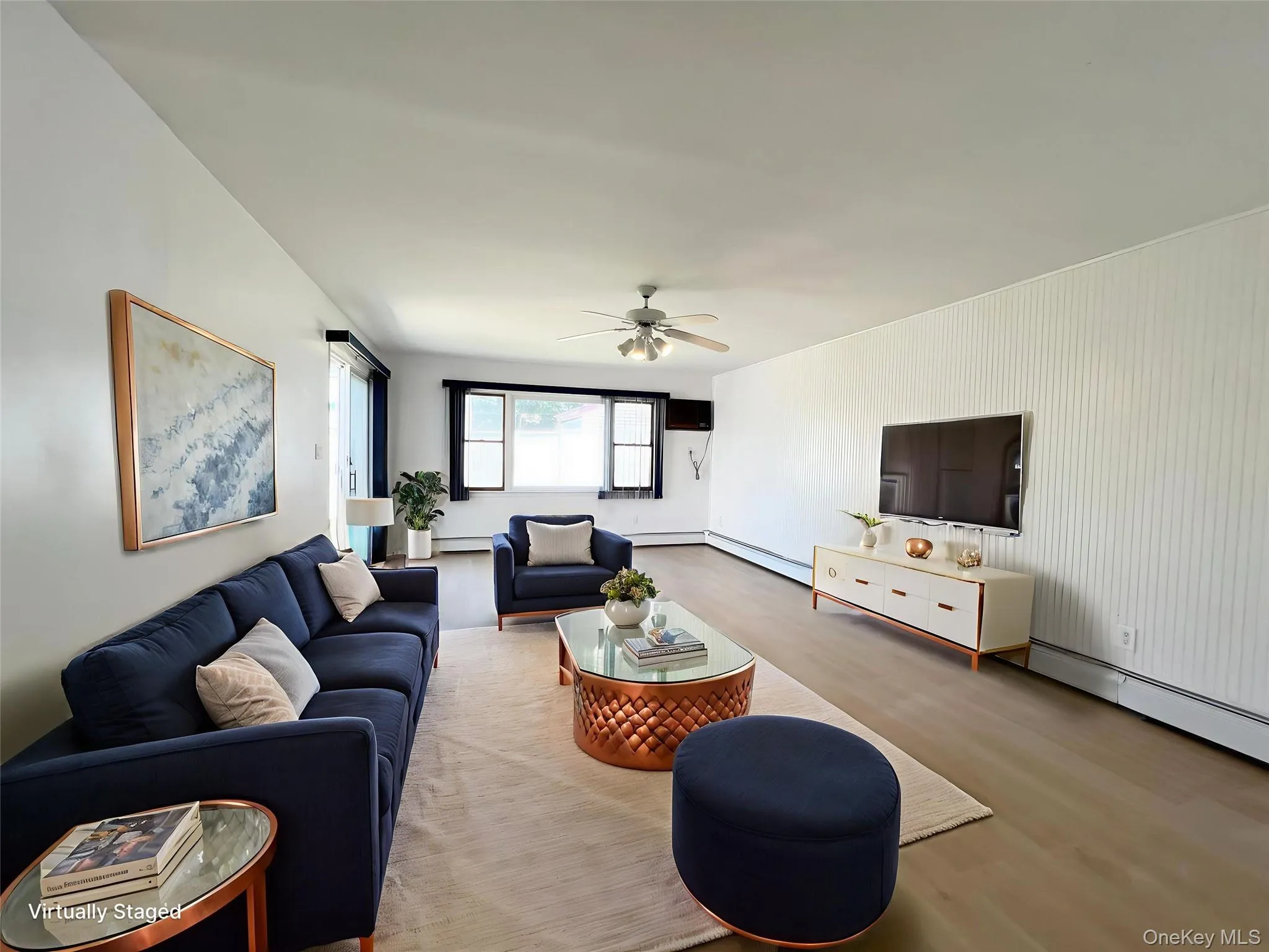 Living area with wood finished floors, a ceiling fan, a baseboard radiator, and baseboard heating Living area with wood finished floors, a ceiling fan, a baseboard radiator, and baseboard heating