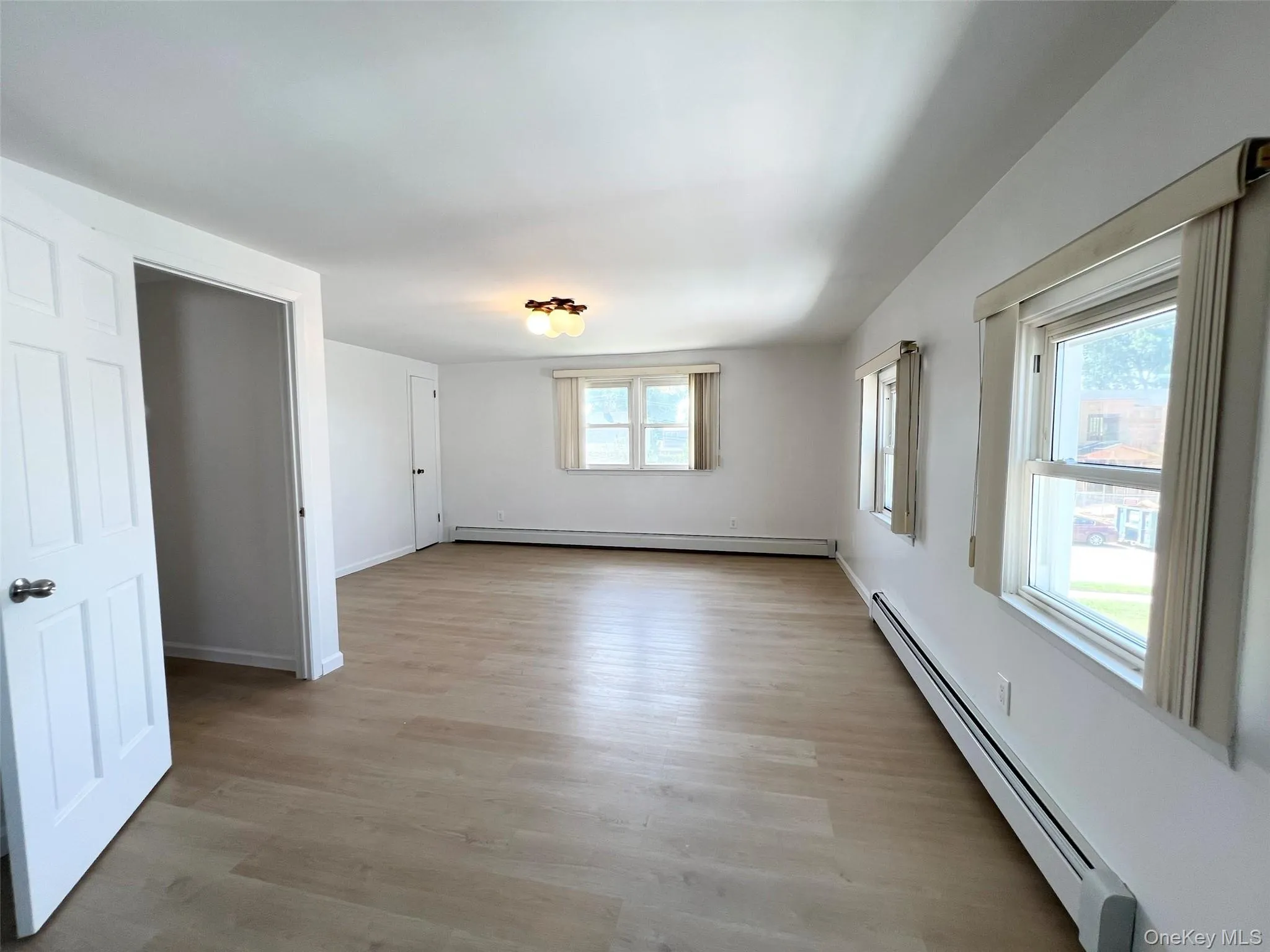 Empty room featuring a baseboard radiator and light wood-style floors Empty room featuring a baseboard radiator and light wood-style floors