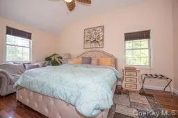 Bedroom with vaulted ceiling and dark wood-style flooring Bedroom with vaulted ceiling and dark wood-style flooring