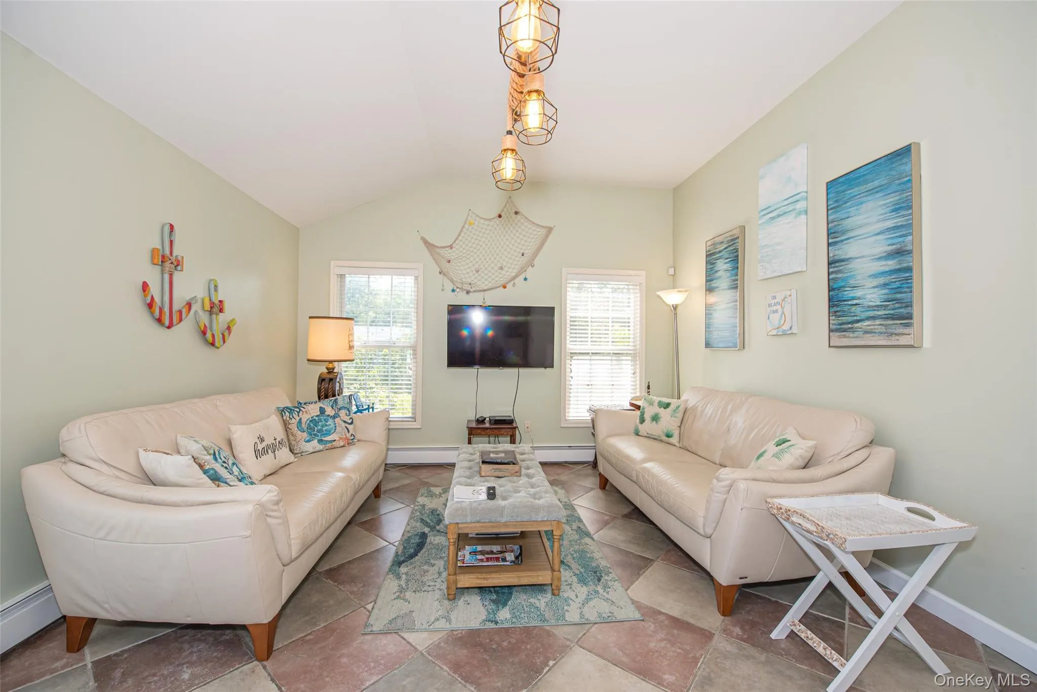 Living area with a baseboard heating unit, vaulted ceiling, and baseboards Living area with a baseboard heating unit, vaulted ceiling, and baseboards