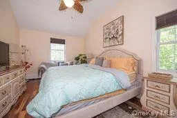 Bedroom with ceiling fan, vaulted ceiling, and dark wood-type flooring Bedroom with ceiling fan, vaulted ceiling, and dark wood-type flooring