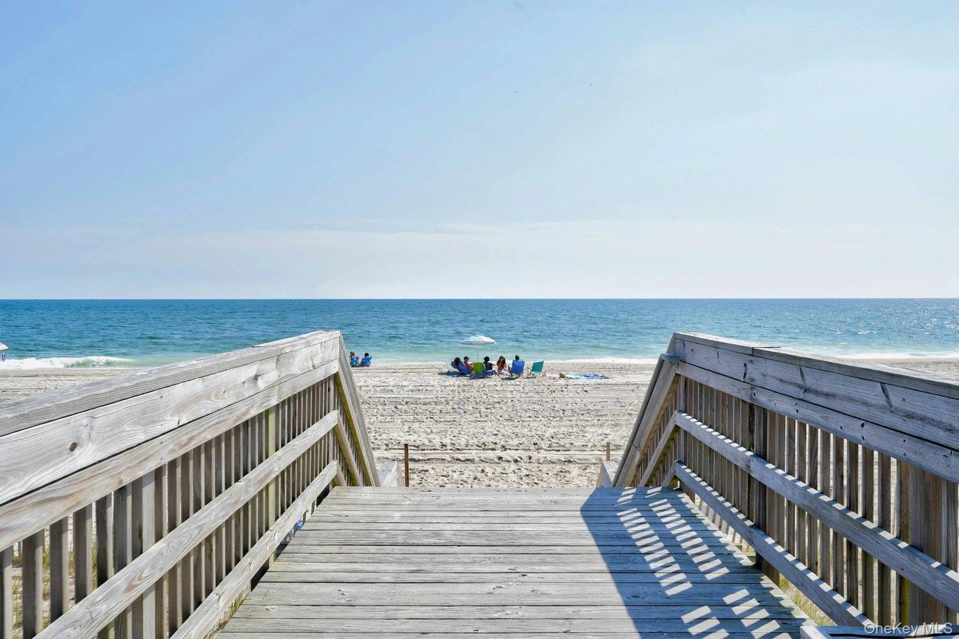 Wooden boardwalk access leading to a sandy beach Wooden boardwalk access leading to a sandy beach