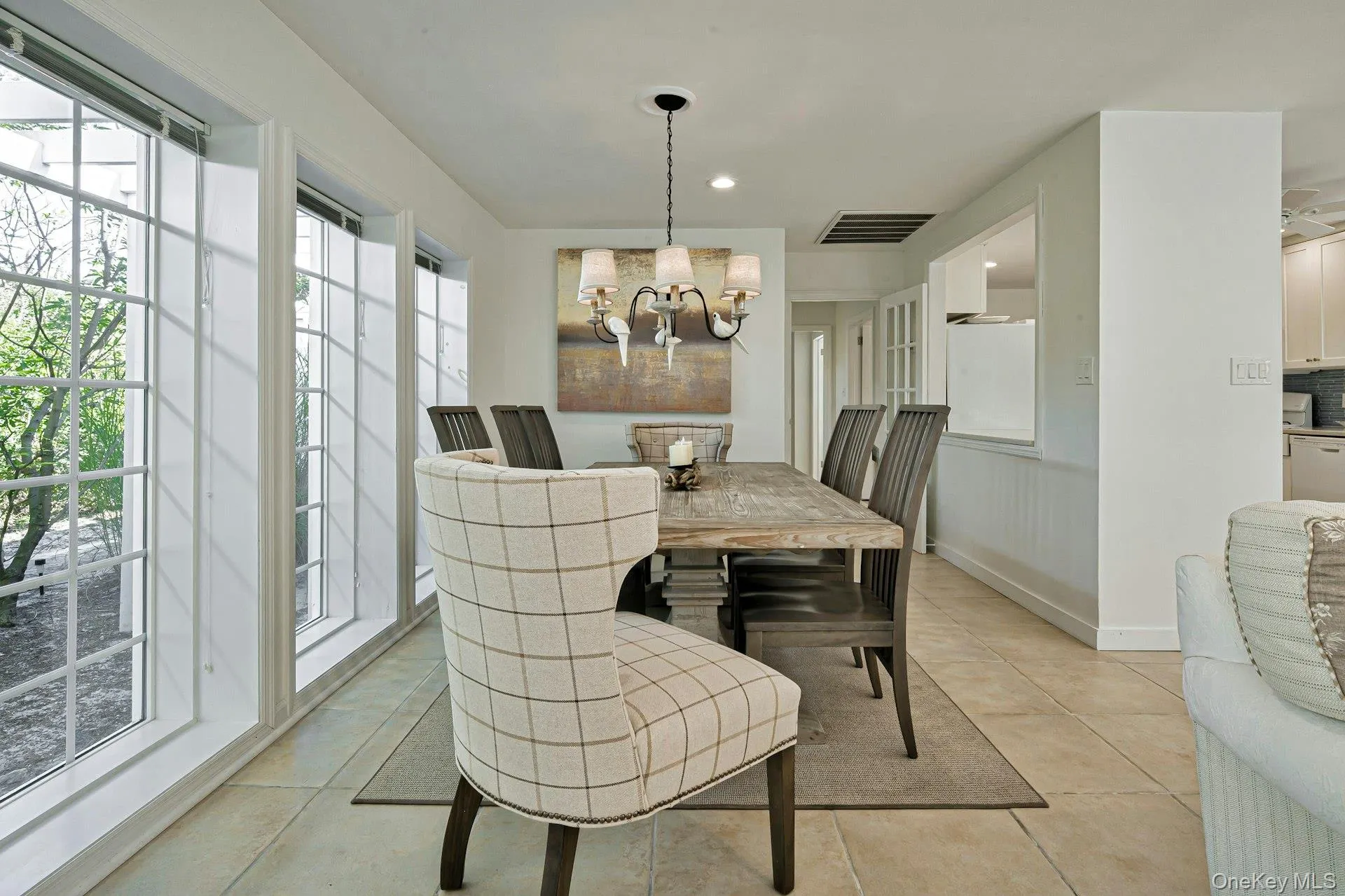 Dining area featuring large grid-pattern windows, a rustic wood-finish dining table, and tile flooring Dining area featuring large grid-pattern windows, a rustic wood-finish dining table, and tile flooring