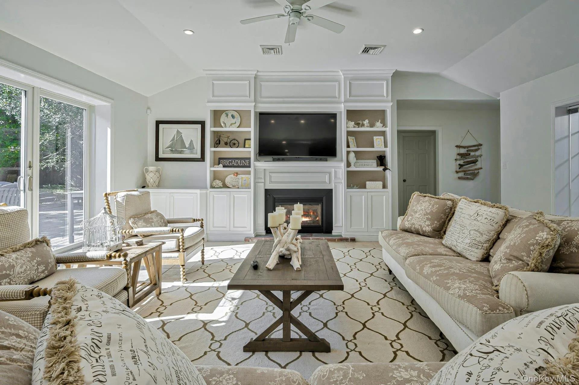 Living area featuring vaulted ceilings, fireplace, recessed lighting, and a ceiling fan Living area featuring vaulted ceilings, fireplace, recessed lighting, and a ceiling fan