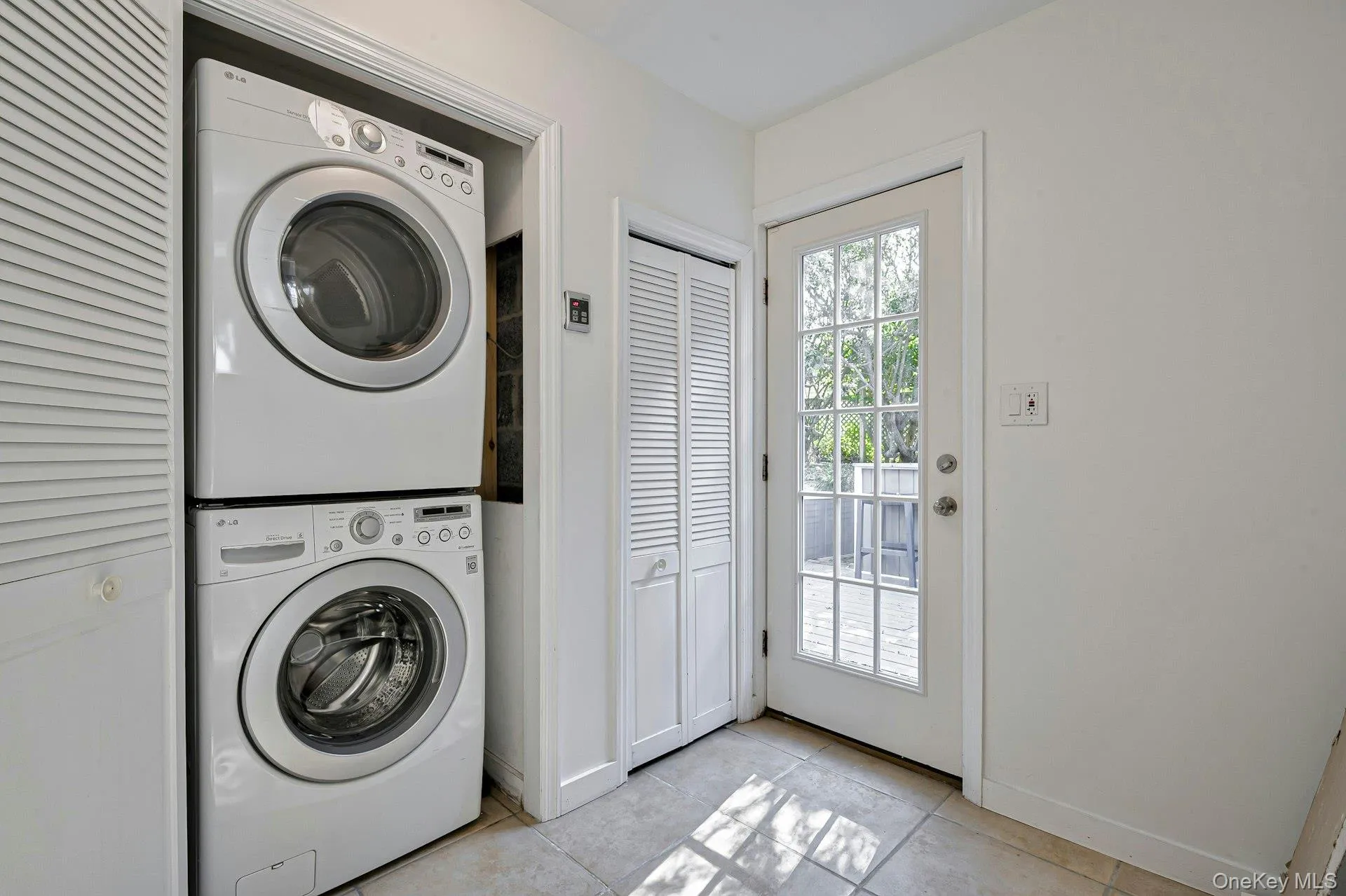 Dedicated laundry area featuring a stacked washer and dryer Dedicated laundry area featuring a stacked washer and dryer