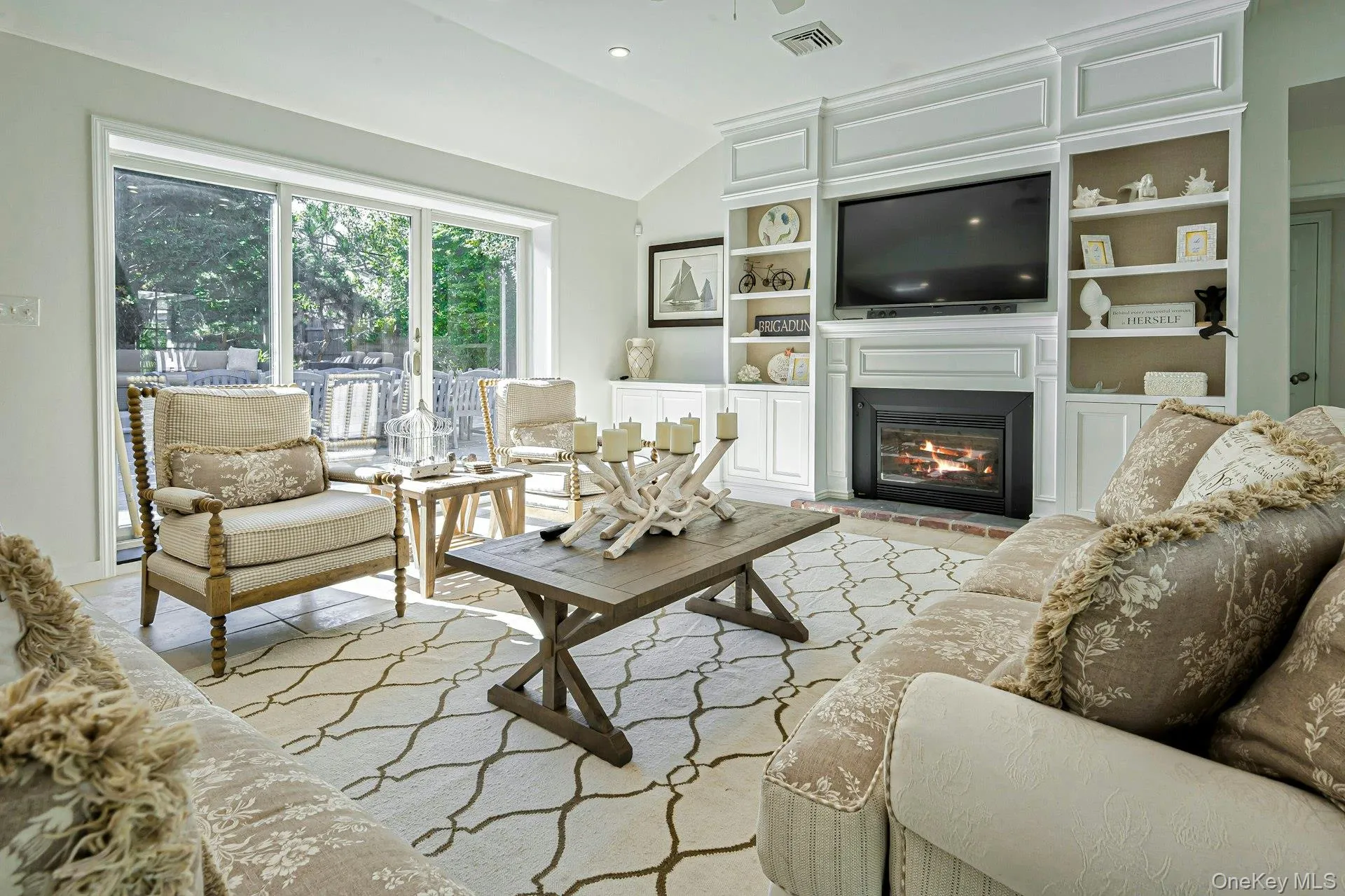 Living area featuring a vaulted ceiling and sliding glass doors to the exterior Living area featuring a vaulted ceiling and sliding glass doors to the exterior