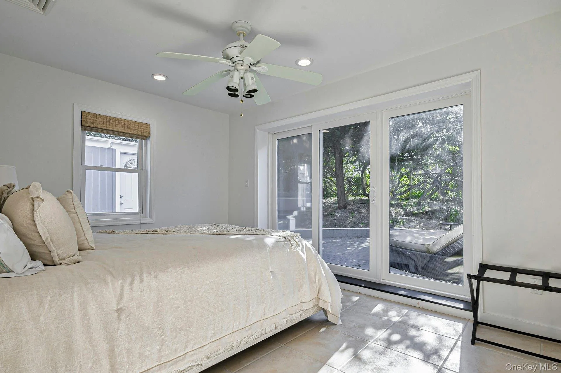 Room featuring a white ceiling fan with integrated lighting, recessed lighting, and a window with a woven shade Room featuring a white ceiling fan with integrated lighting, recessed lighting, and a window with a woven shade