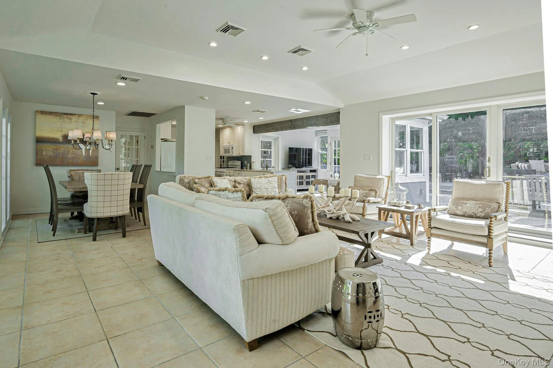 Spacious living area featuring light tile flooring, recessed lighting, and a ceiling fan Spacious living area featuring light tile flooring, recessed lighting, and a ceiling fan
