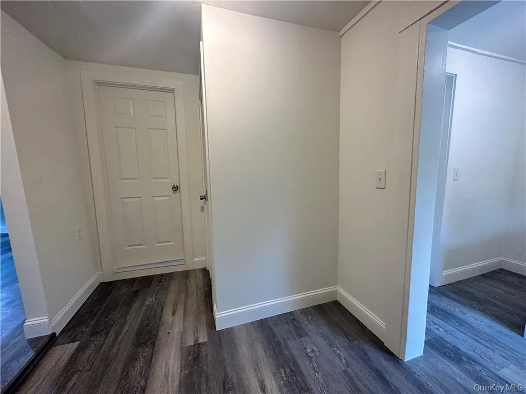 Hallway featuring dark wood-type flooring Hallway featuring dark wood-type flooring