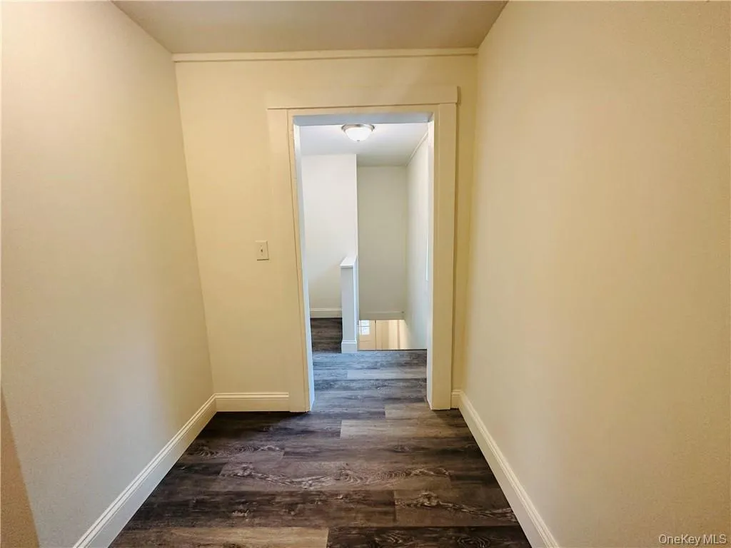 Hallway featuring dark wood-type flooring Hallway featuring dark wood-type flooring