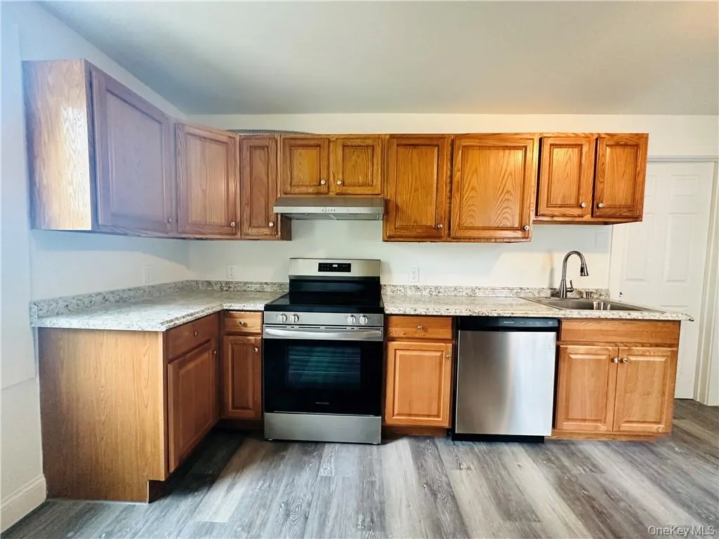 Kitchen with sink, hardwood / wood-style flooring, and stainless steel appliances Kitchen with sink, hardwood / wood-style flooring, and stainless steel appliances