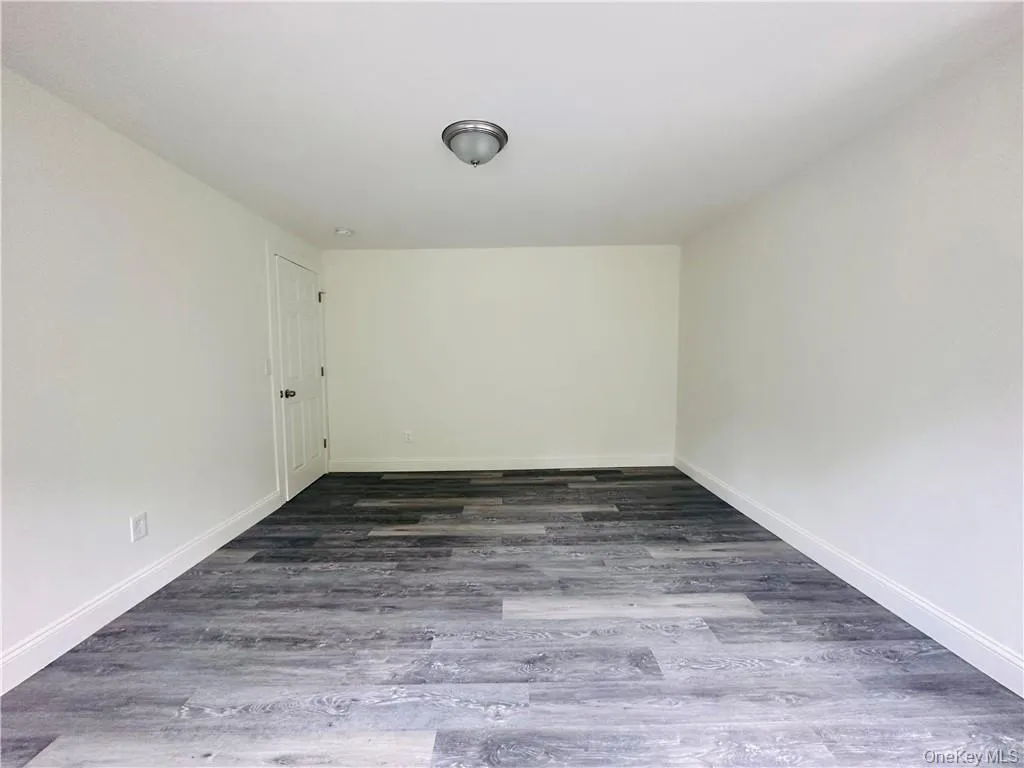 Spare room featuring dark hardwood / wood-style flooring Spare room featuring dark hardwood / wood-style flooring