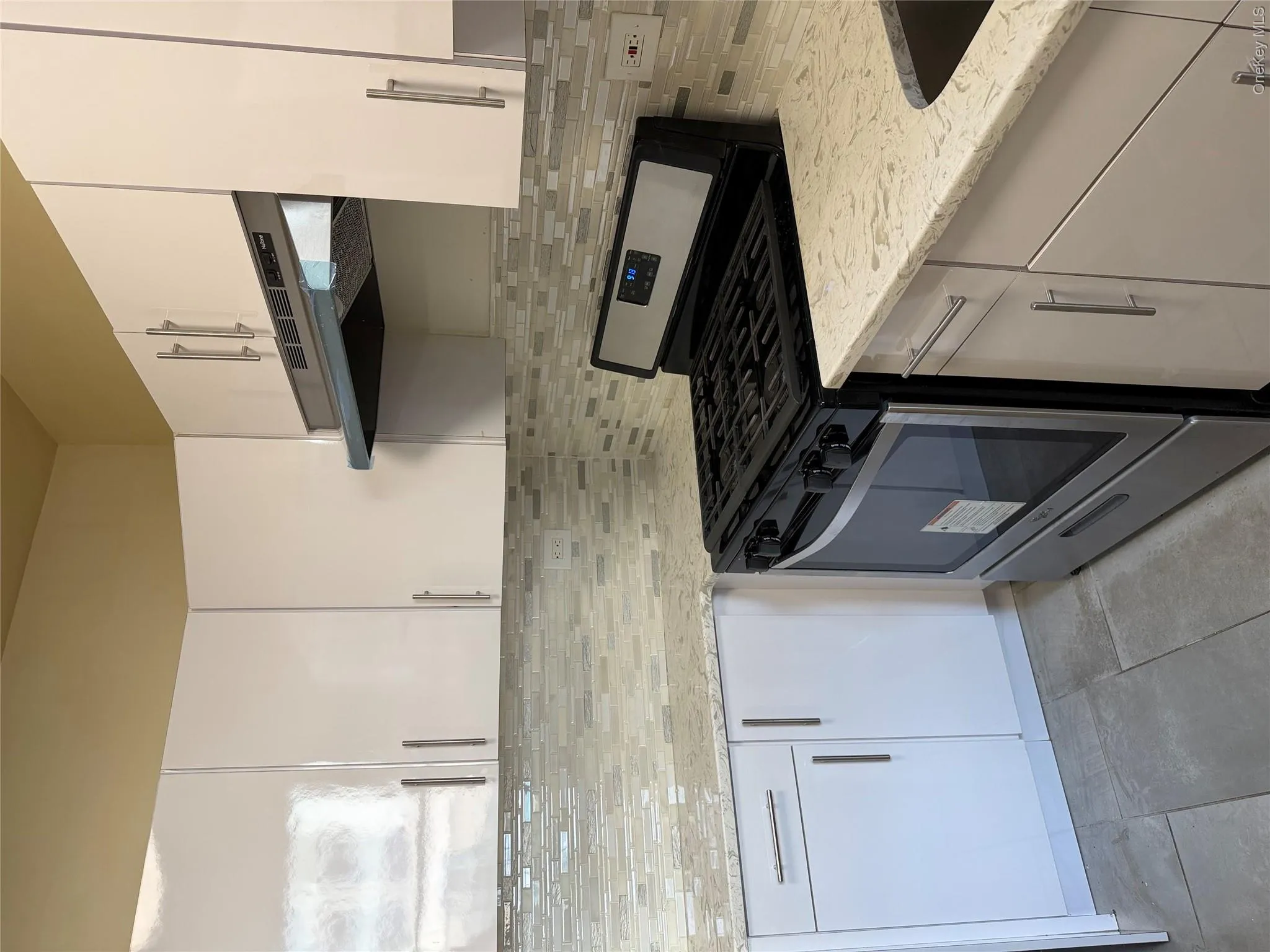 Modern kitchen featuring white cabinetry with brushed nickel hardware Modern kitchen featuring white cabinetry with brushed nickel hardware