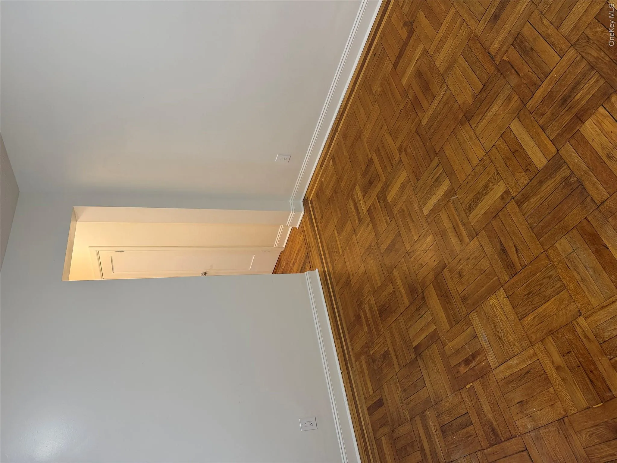 Parquet wood flooring with white baseboards and neutral wall tones Parquet wood flooring with white baseboards and neutral wall tones