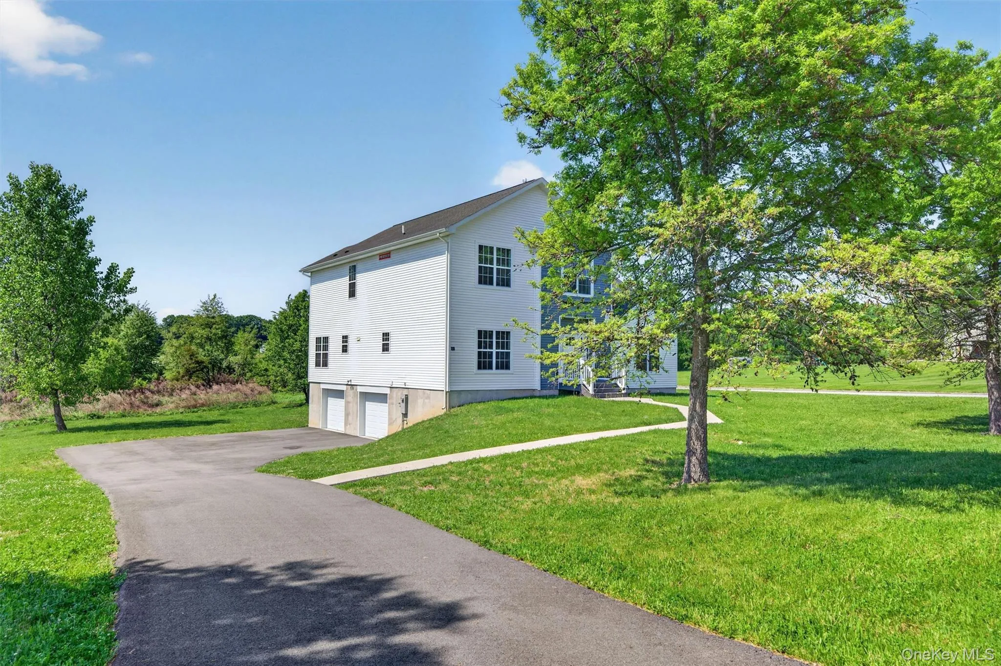 Side of the house with a spacious paved driveway. Side of the house with a spacious paved driveway.