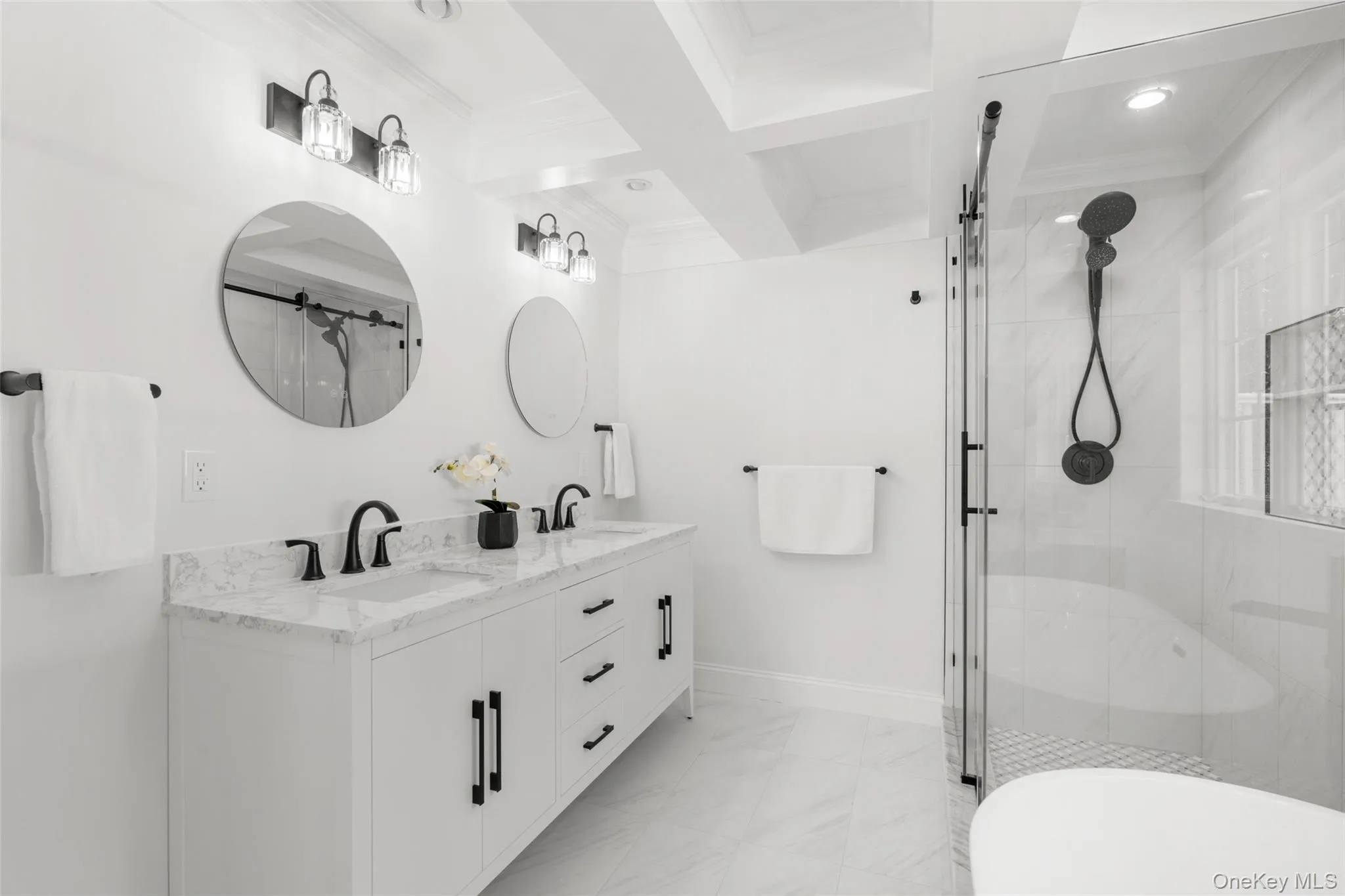 Spa-like bath with coffered ceiling, elegant lighting and dual sinks. Spa-like bath with coffered ceiling, elegant lighting and dual sinks.