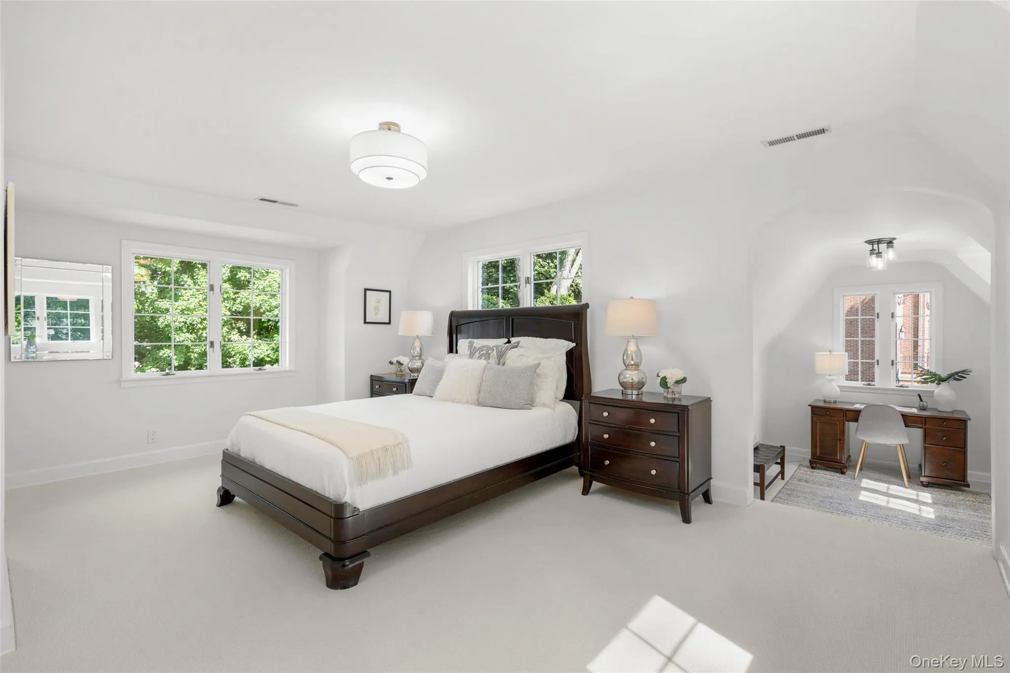 Expansive primary bedroom retreat with abundant natural light and sitting area or workspace. Expansive primary bedroom retreat with abundant natural light and sitting area or workspace.