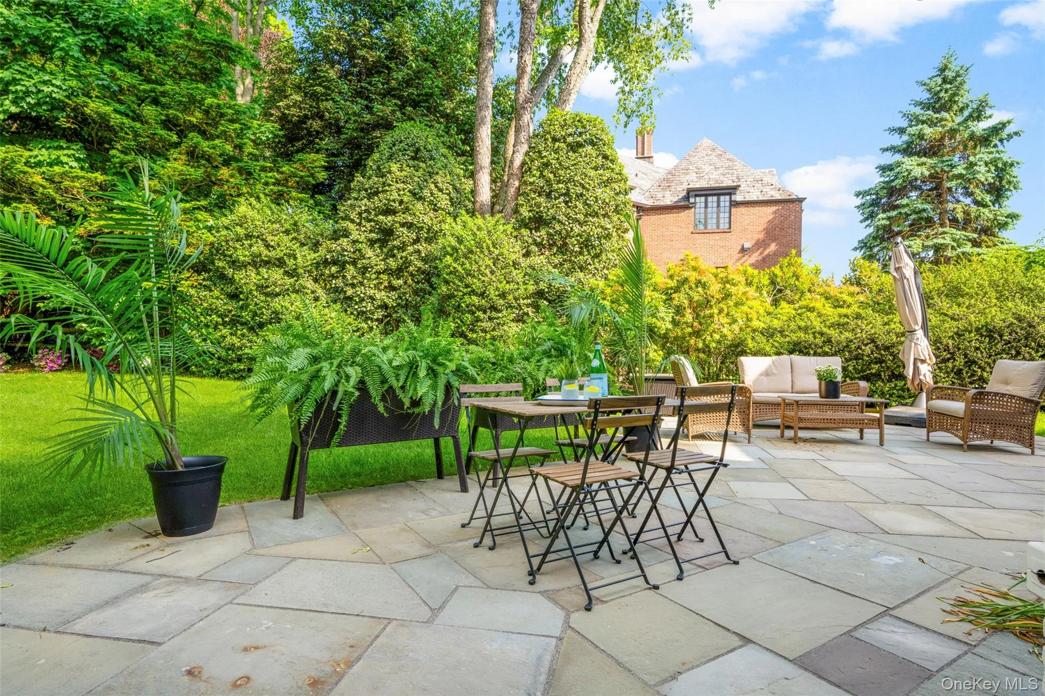 Tranquil outdoor entertaining space with bluestone patio and lush landscaped surroundings Tranquil outdoor entertaining space with bluestone patio and lush landscaped surroundings