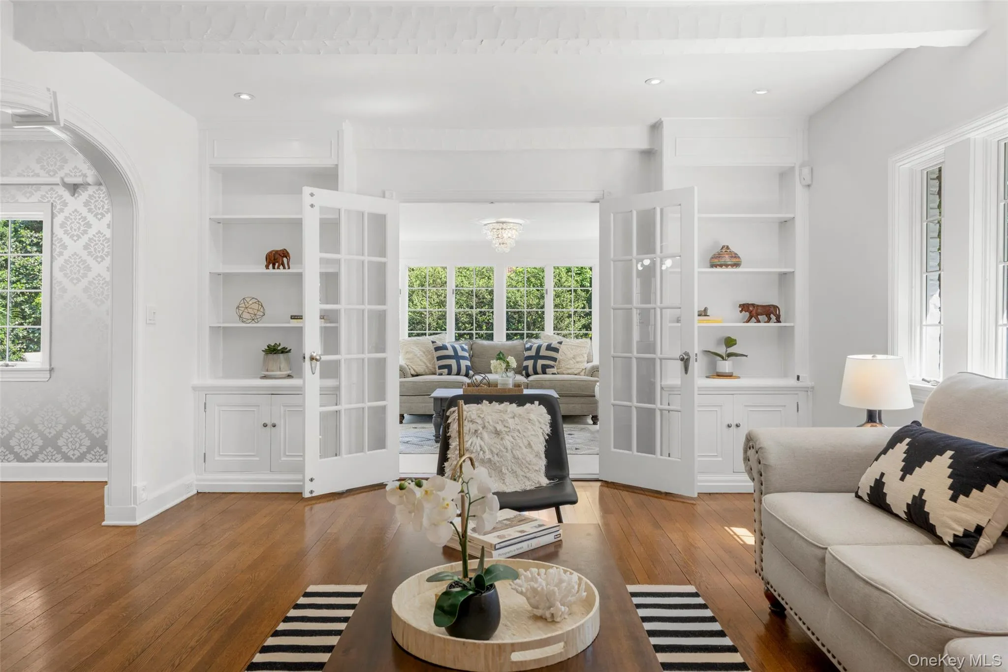French doors and built in bookcases lead to a sun filled family room French doors and built in bookcases lead to a sun filled family room