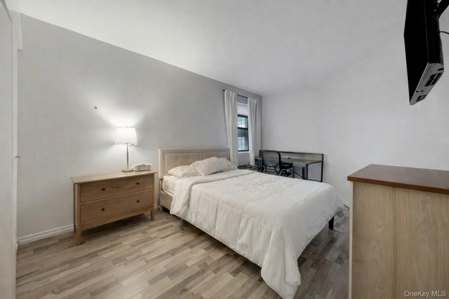 Bedroom featuring light wood finished floors and vaulted ceiling Bedroom featuring light wood finished floors and vaulted ceiling