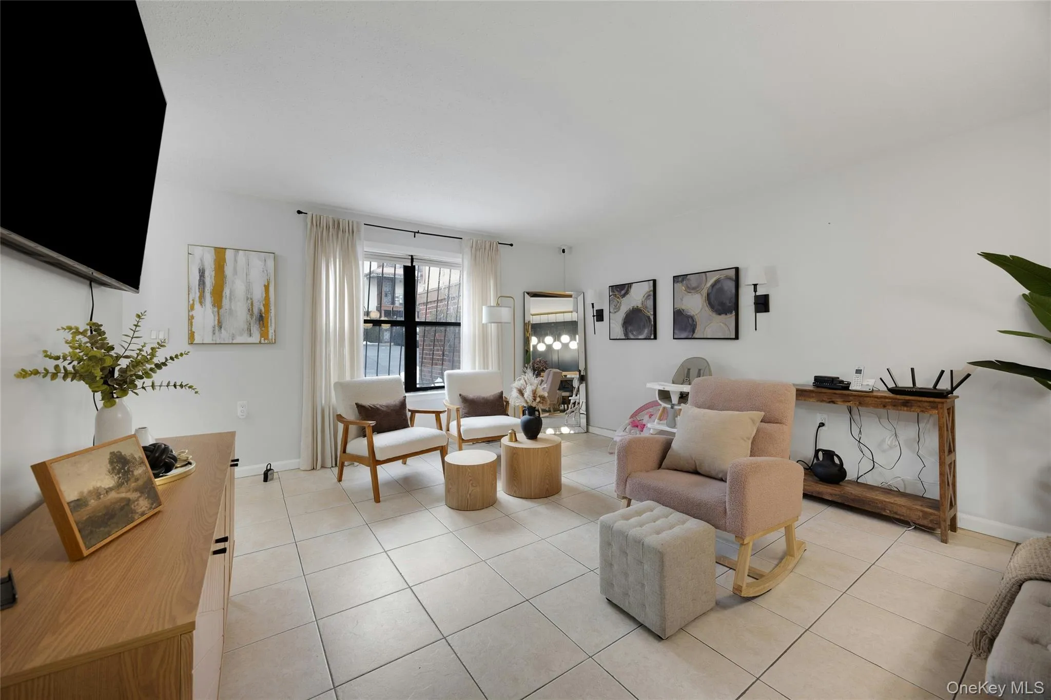 Living room featuring light tile patterned flooring and baseboards Living room featuring light tile patterned flooring and baseboards