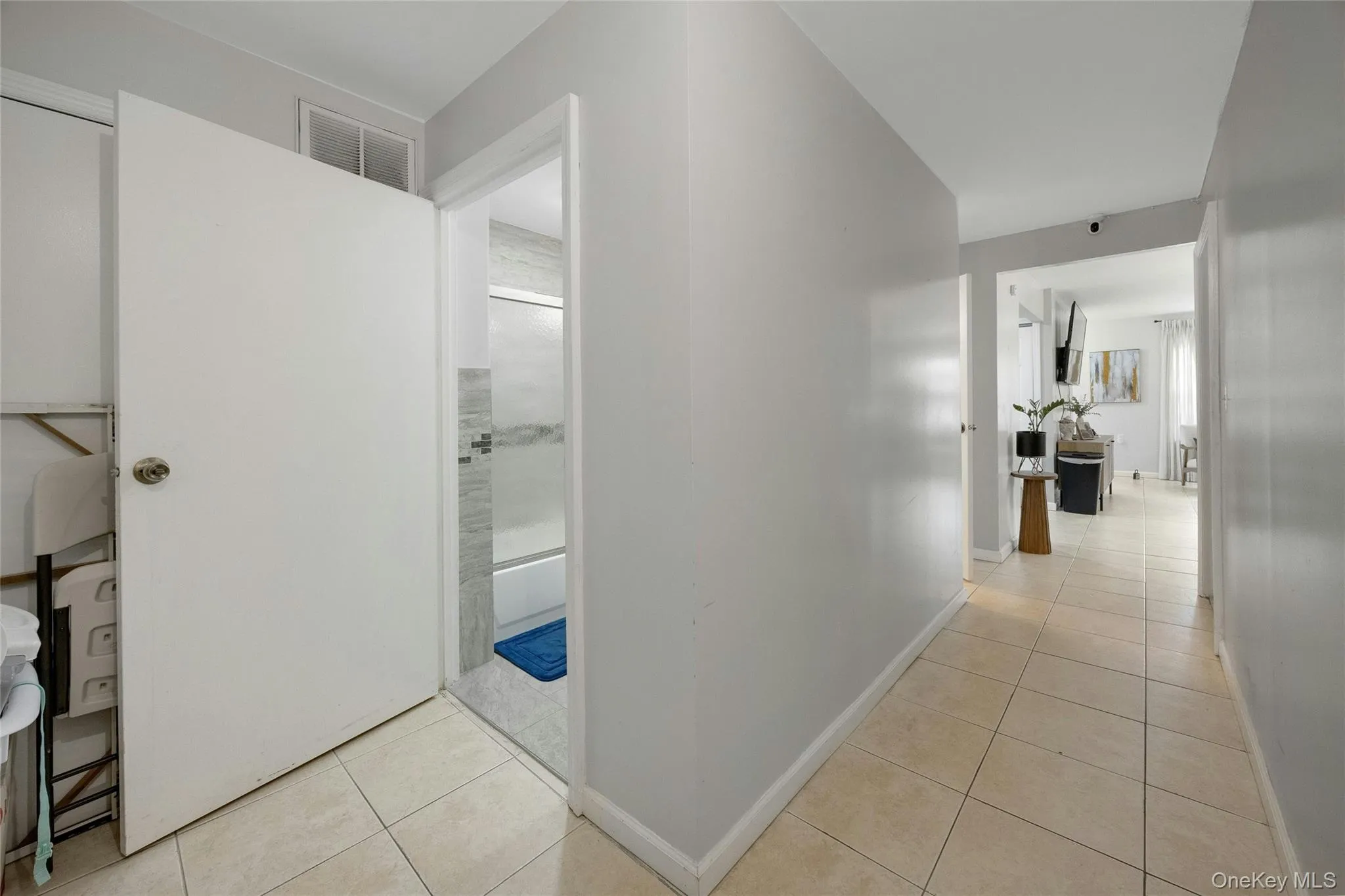 Hallway with light tile patterned flooring and baseboards Hallway with light tile patterned flooring and baseboards