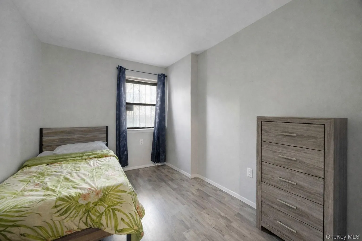 Bedroom with light wood-style flooring and baseboards Bedroom with light wood-style flooring and baseboards